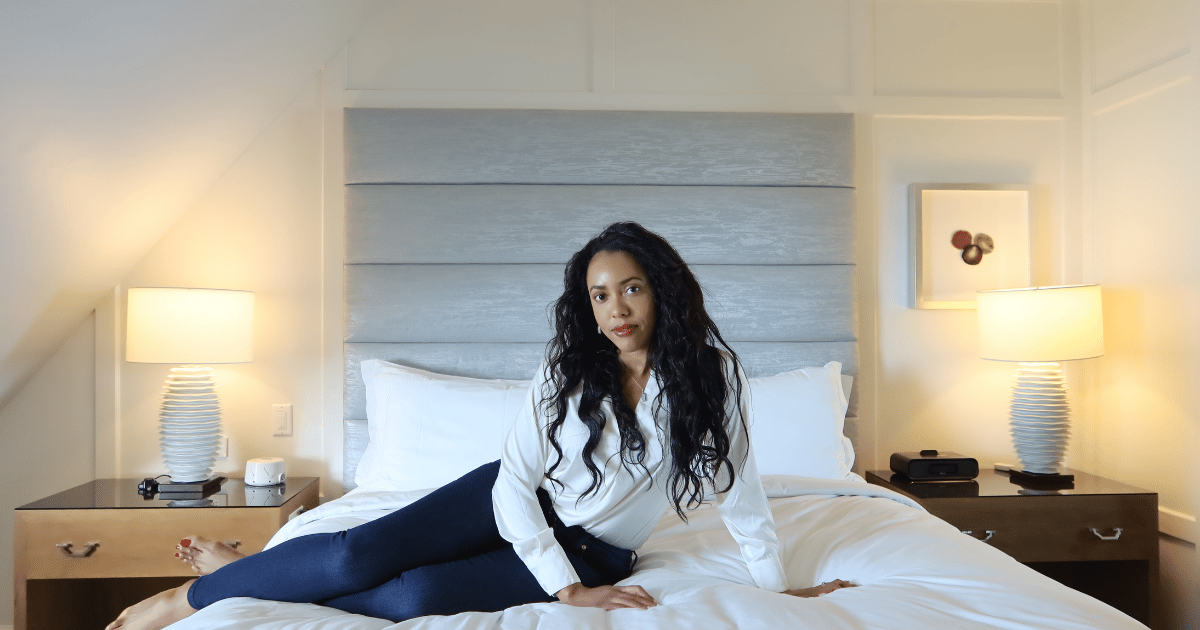 beautiful black woman sitting on luxury bed in hotel